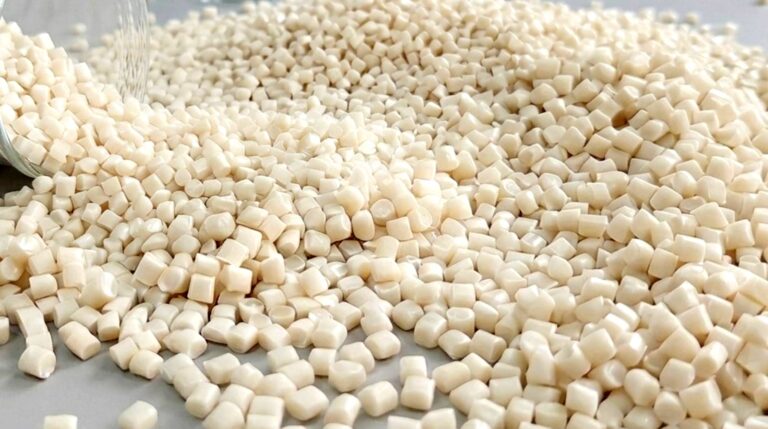 Macro view of raw PHA bioplastic pellets utilized as certified compostable materials and high-performance plastic replacement materials for industrial manufacturing.